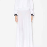Front view of white batwing jumper on model wearing white maxi dress underneath, against a white background.