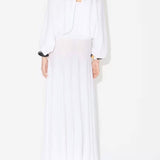 Back view of white batwing jumper on model wearing white maxi dress underneath, against a white background.