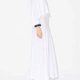 Side view of white batwing jumper on model wearing white maxi dress underneath, against a white background.