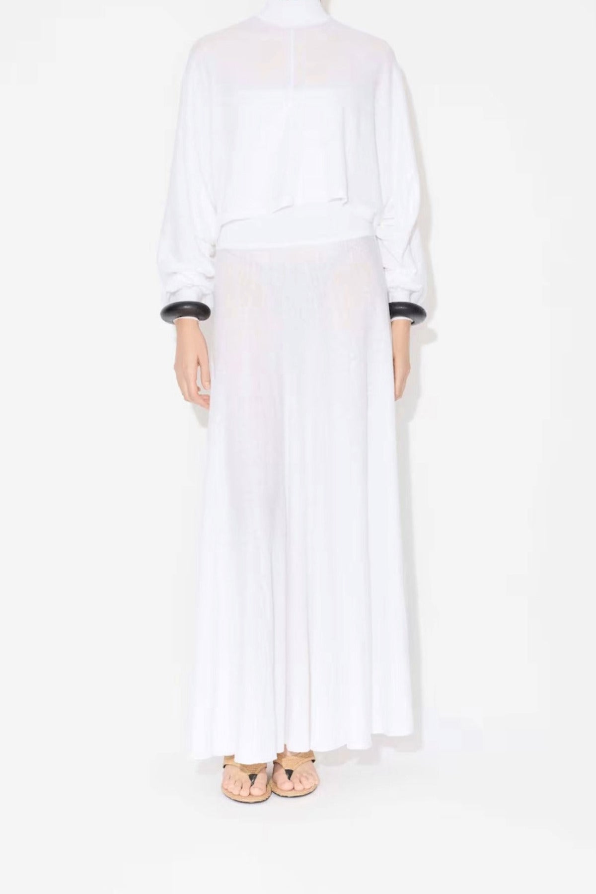 Front view of linen white dress on model wearing white pullover, and natural wedge sandals, against white background.
