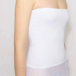 Front slanted closeup view of white linen maxi dress on model against white background.