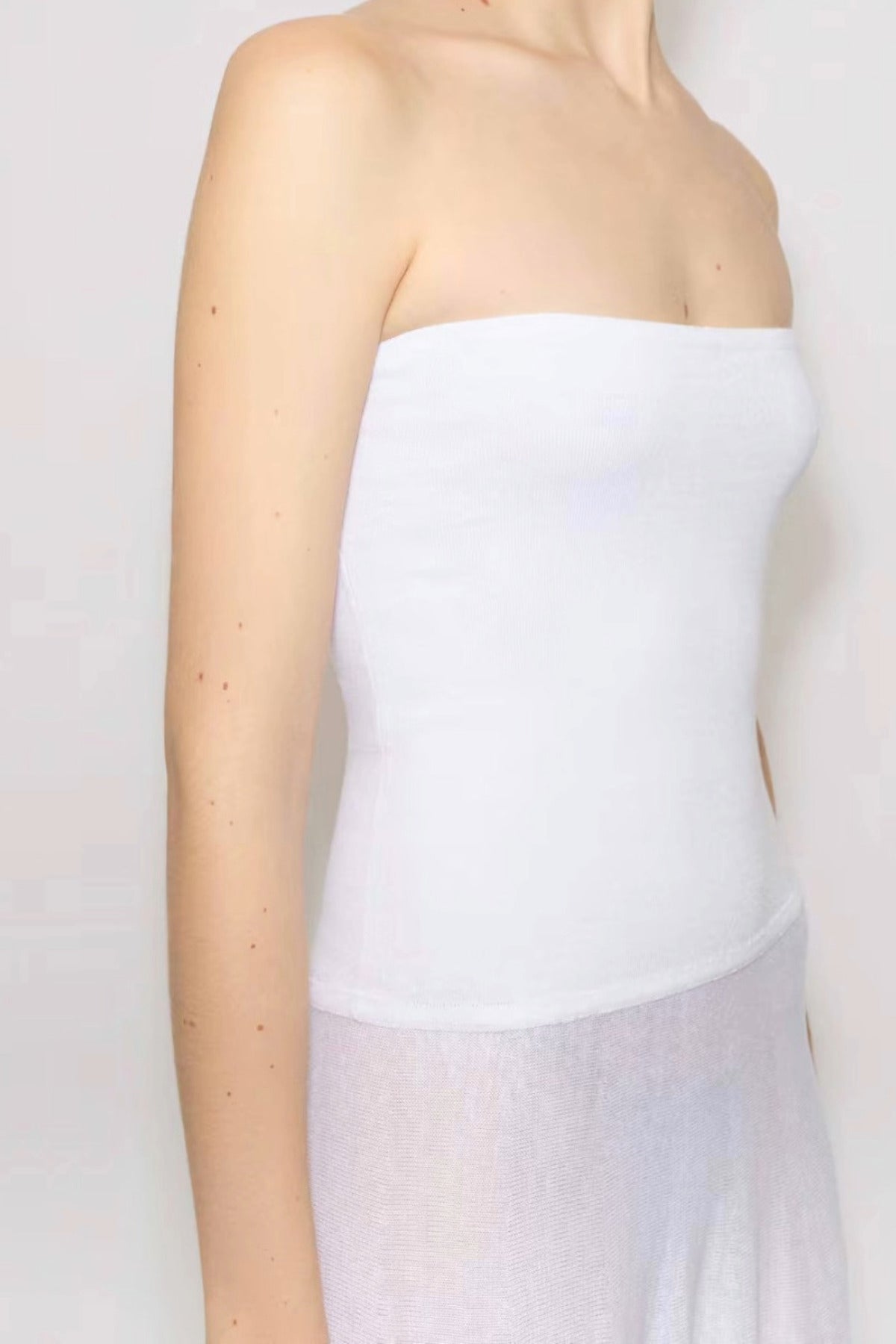 Front slanted closeup view of white linen maxi dress on model against white background.