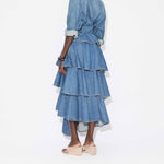 Back view of bleu mineral spiral skirt on model wearing denim top and natural sandals, against a white background