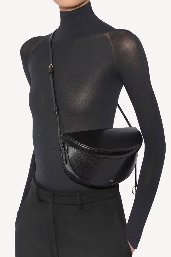 Alternate front view of noir hip east west bag on model wearing black top and pants, against a white background.