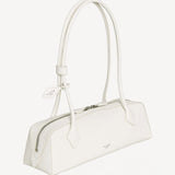 Side slanted view of ivoire le teckel medium bag on white background, with no model shown.