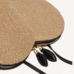 Side closeup view of the natural heart bag in straw on white background, with no model shown.