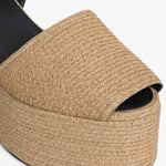 Left side closeup of natural wedge slingback in paper straw, against white background, with no model shown.