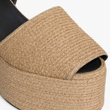 Left side closeup of natural wedge slingback in paper straw, against white background, with no model shown.