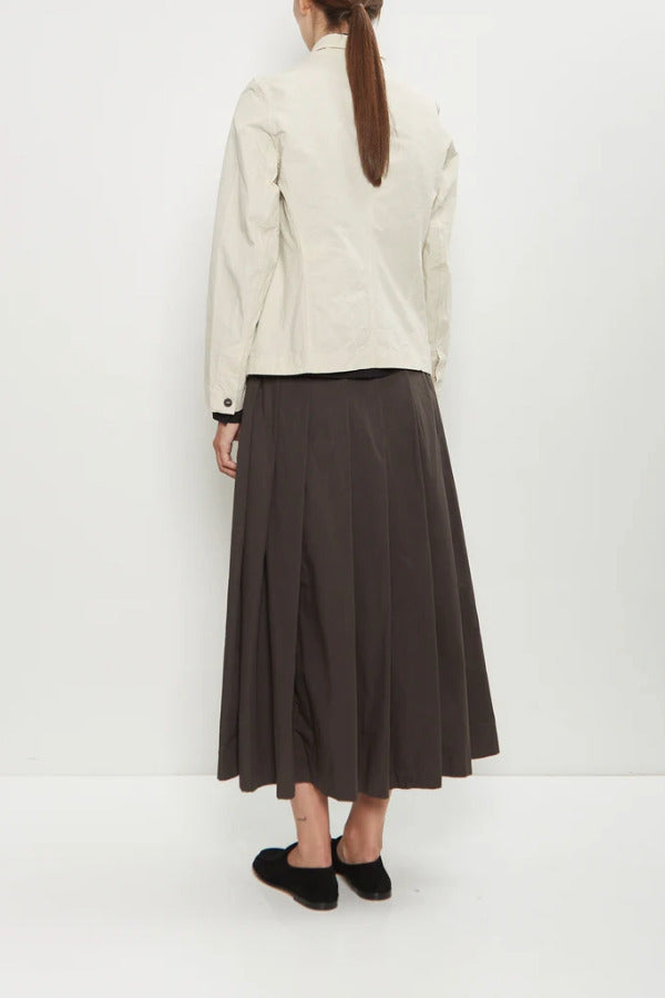 Back view of stone caryl jacket on model wearing brown skirt and black loafers, against a white background.