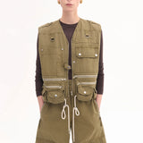 Front view of olive hunters gilet on model wearing a brown shirt and olive trousers, against a white background.