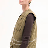 Side view of olive hunters gilet on model wearing brown shirt and olive trousers, against a white background.