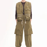 Front view of olive hunters gilet on model wearing brown shirt, olive trousers and brown pointed toe heels, against a white background.