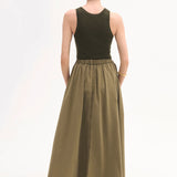 Back view of olive parachute skirt on model wearing dark green tank top and black sandals, against white background.
