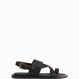 The left black leather sandal is shown in a side view profile with buckle shown in the back on white background.