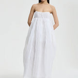 Front view of white vilma dress on model wearing pink sneakers, against a white background.