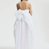 Back view of white vilma dress on model wearing pink sneakers, against a white background.