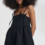 Front closeup view of black ambra dress on model, against a white background.