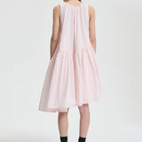 Back view of blush pink azelia dress on model wearing black sneakers and socks, against a white background.