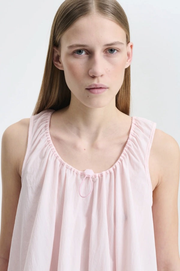 Front closeup view of blush pink azelia dress on model, against a white background.