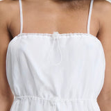 Front closeup view of white barr dress on model, against a white background.