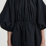 Front closeup of black birgitte dress on model, against a white background.