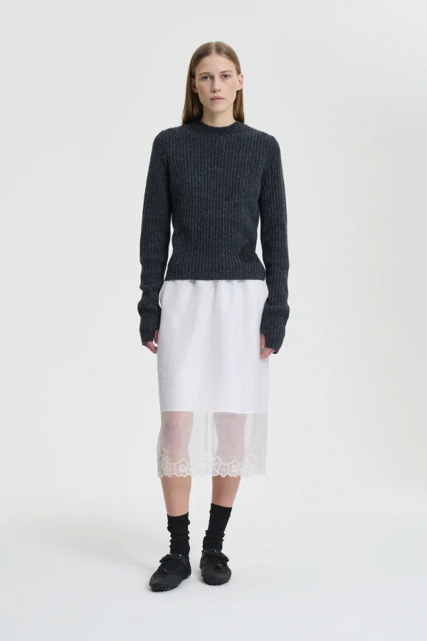 Front view of white bria skirt on model wearing grey sweater and black sneakers, against a white background.