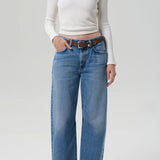 Front view of miro jean in corrin on model wearing a white t-shirt and brown heels, against a white background.