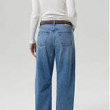 Back view of miro jean in corrin on model wearing a white t-shirt and brown heels, against a white background.
