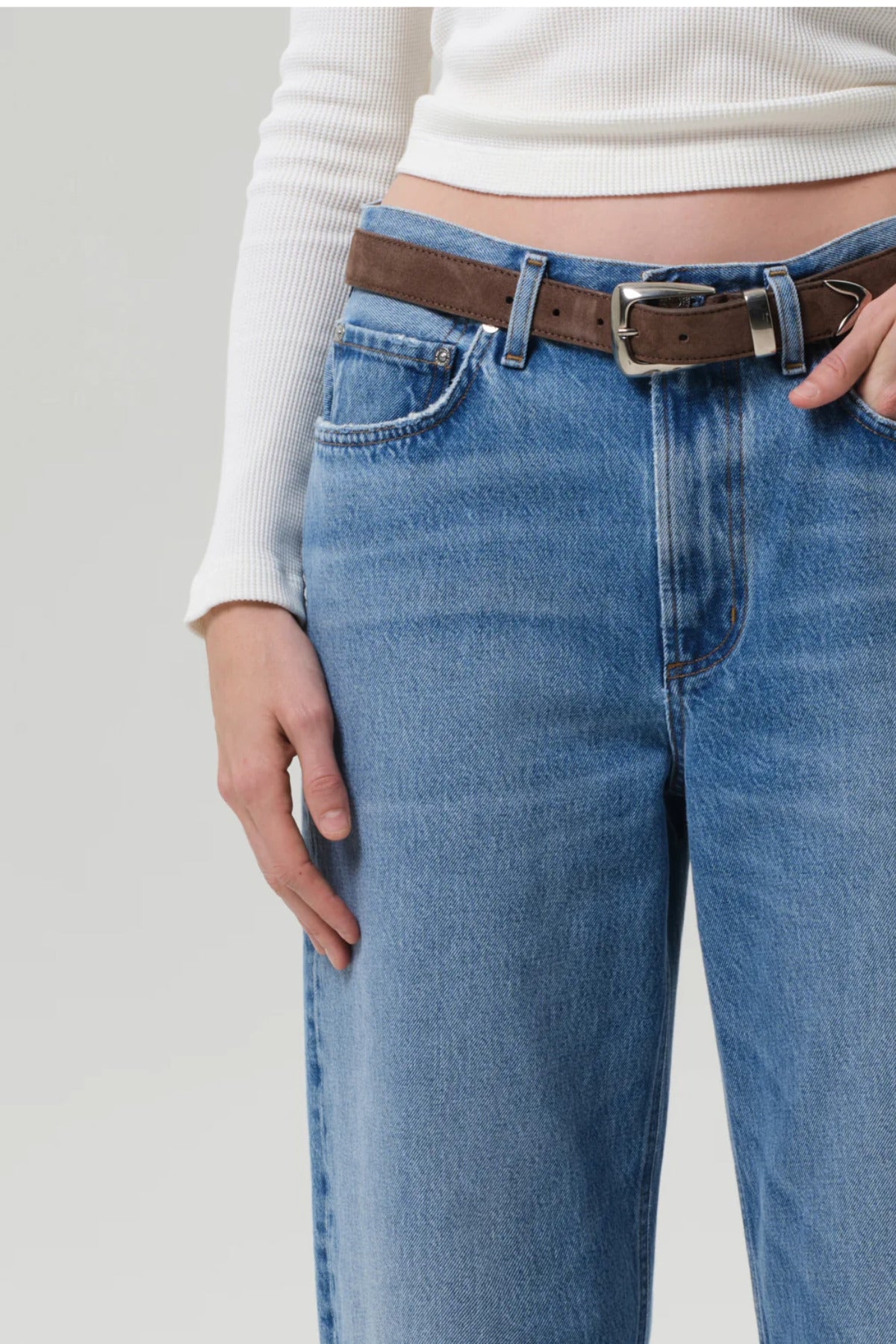 Front closeup of miro jean in corrin on model wearing white t-shirt and brown belt, against a white background.
