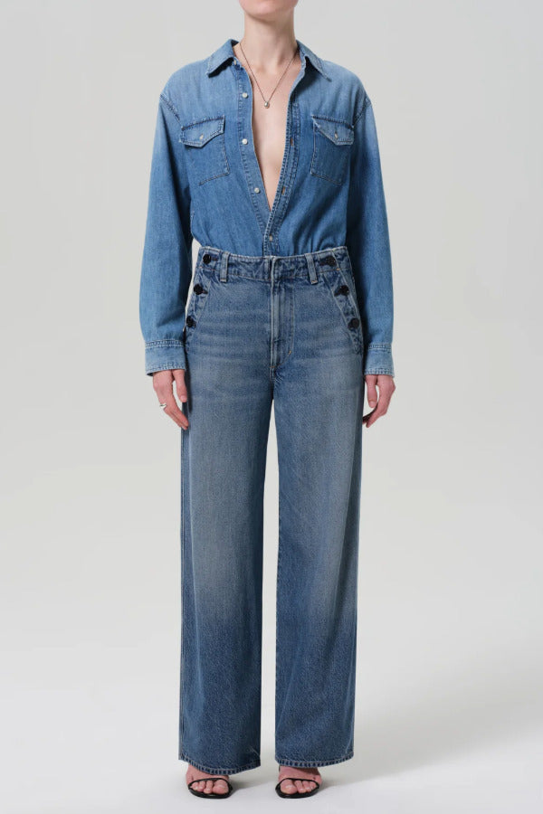 Front view of boardwalk trouser in jete on model wearing jean shirt and black heels, against a white background.