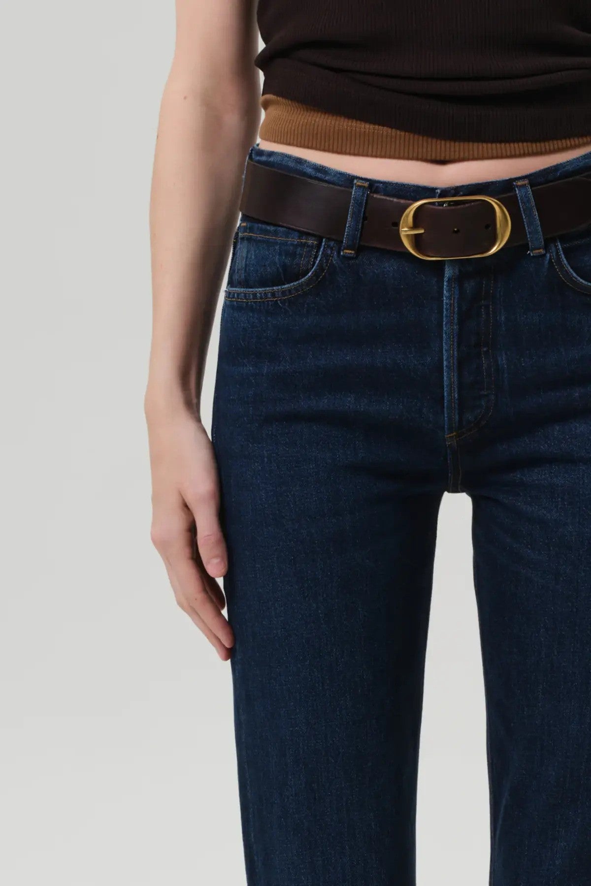 Front closeup view of blaine jean in medina on model wearing black and white tank tops with a brown and gold belt, against a white background.