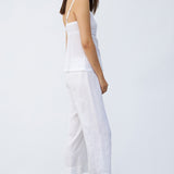 Side view of rice kymber camisole on model wearing rice pants and natural sandals, against a white background.