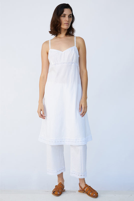 Front view of rice kymber slip on model wearing natural sandals, against a white background.