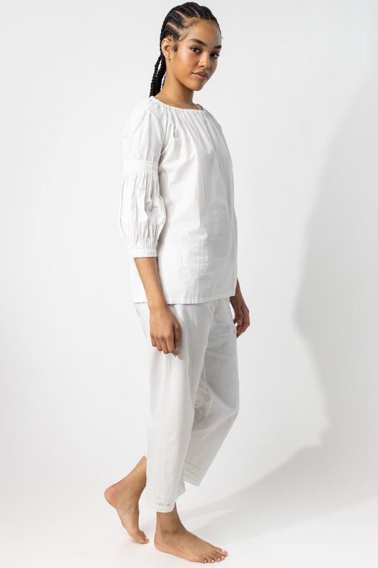 Side view of rice pants with lace on model wearing rice top, against a white background.