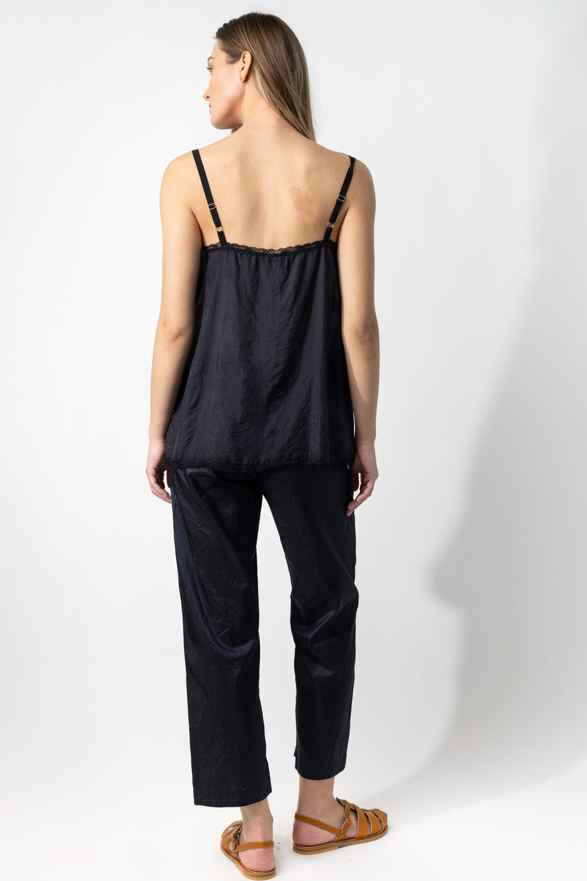 Back view of midnight short chemise on model wearing midnight pants and natural sandals, against a white background
