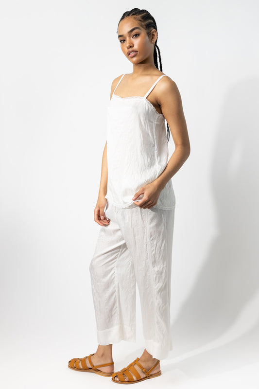 Side view of rice wide leg pants on model wearing rice top and natural sandals, against a white background.