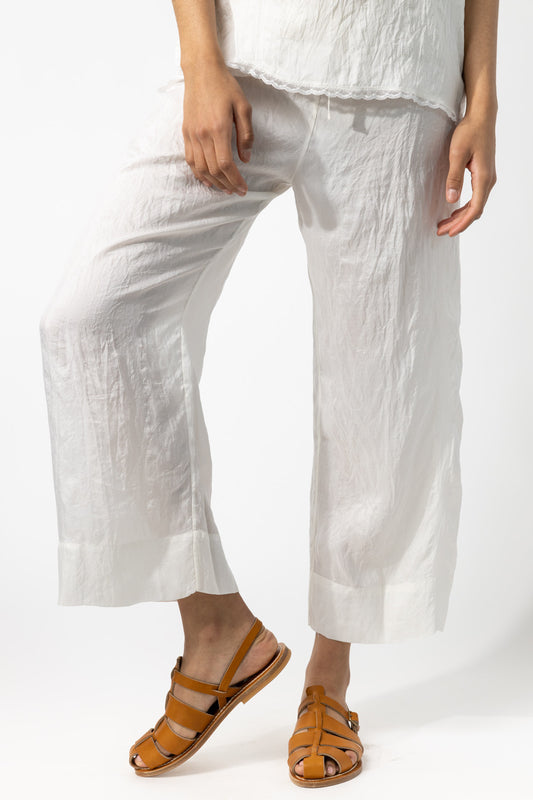Front closeup view of rice wide leg pants on model wearing rice top and natural sandals, against a white background.