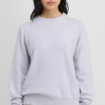 Front view of heaven be classic sweater on dark-haired model wearing white trousers, against a white background
