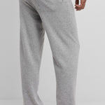 Back view of grey no 320 rush trouser on model wearing white t-shirt and sandals, against a white background.