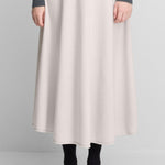 Front view of chalk no 388 ease skirt on model wearing grey sweater and black heels, against a white background.