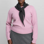 Front view of rosa no 430 jeanne sweater on model wearing grey skirt, against a white background.
