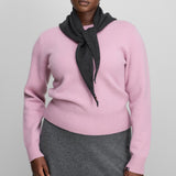 Front view of rosa no 430 jeanne sweater on model wearing grey skirt, against a white background.