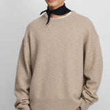 Front view of oat no 431 mike sweater on model wearing grey pants, against a white background.