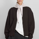 Front view of dark brown no 436 luce cardigan on model wearing white shirt and grey skirt, against a white background.
