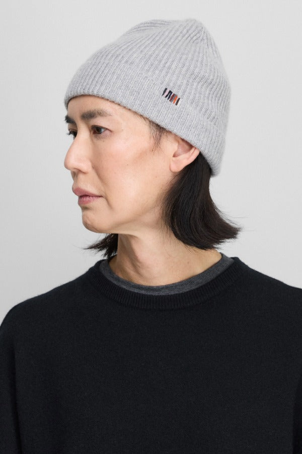 Side view of grey no 444 hat on model wearing black sweater, against a white background.