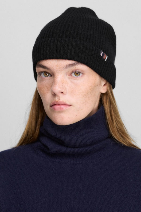 Front view of raven no 444 hat on model wearing navy sweater, against a white background.