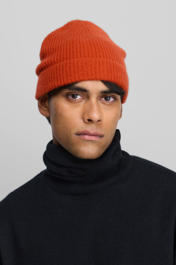 Front view of dark orange no 444 hat on model wearing raven sweater, against a white background.