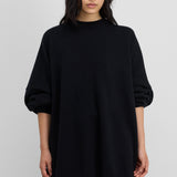 Front view of raven juna sweater on model wearing grey leggings and skirt, against a white background.