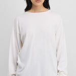 Front view of snow aries sweater on model wearing black trousers, against a white background.