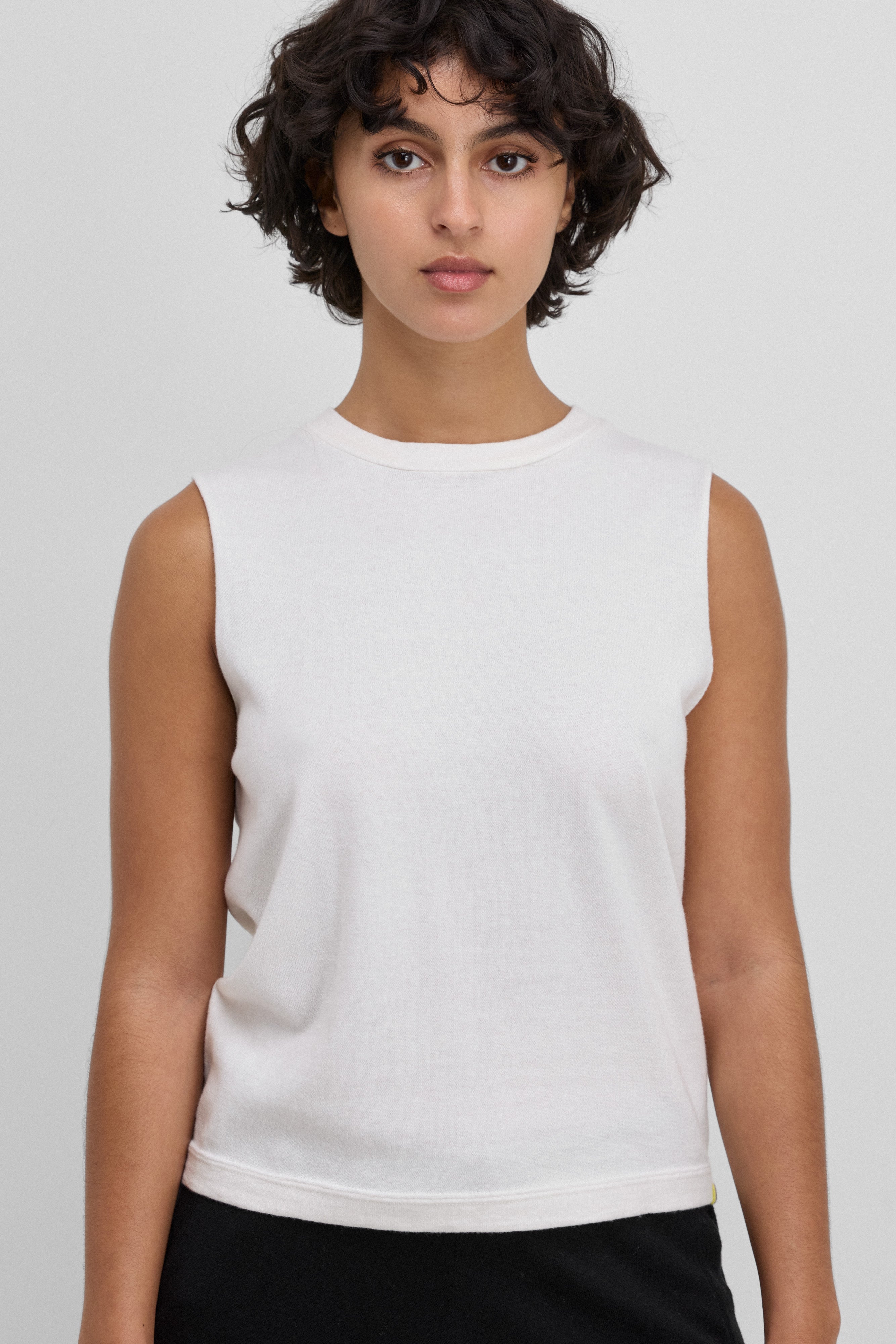 Front view of snow payer top on model wearing black pants, against white background.